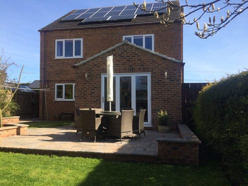 patio in front of house with chairs and table